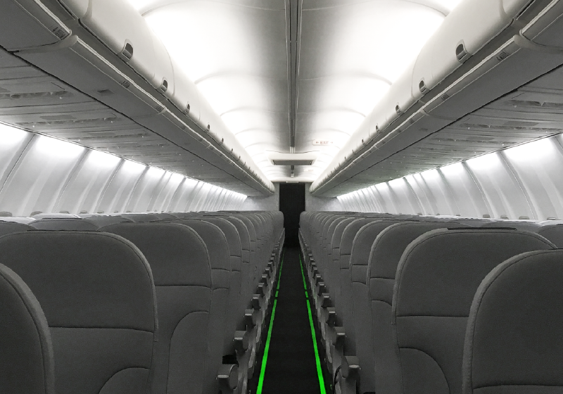 GLS-7 photoluminescent floor path marking system shown in the interior of an aircraft cabin, lighting a path to the exit.